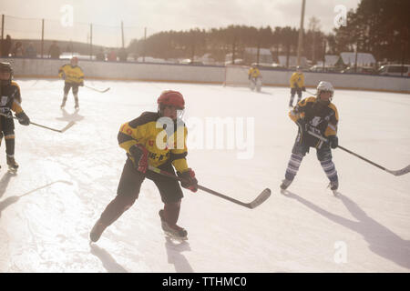 Ragazzi giocare hockey su ghiaccio sulla giornata di sole Foto Stock