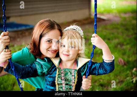 Ritratto di felice madre e figlia gioca su swing Foto Stock