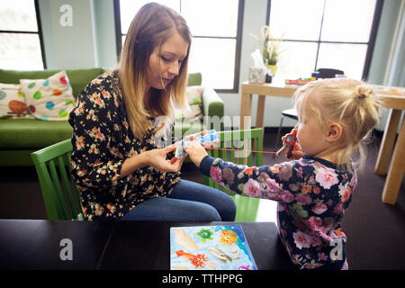 Femmina e ragazza che gioca con magnetico gioco della pesca a casa Foto Stock