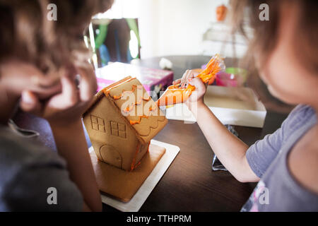 Le ragazze di decorazione Casa di panpepato a casa Foto Stock