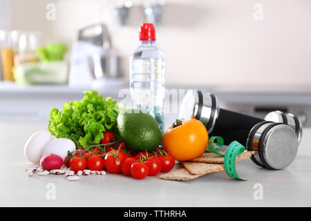 Set di frutta fresca e verdura con manubri sul tavolo di legno closeup Foto Stock