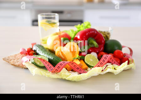 La frutta e la verdura fresca con nastro di misurazione sul tavolo di legno, vista dall'alto Foto Stock