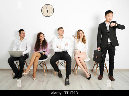 Un gruppo di persone in attesa per l'intervista al chiuso Foto Stock