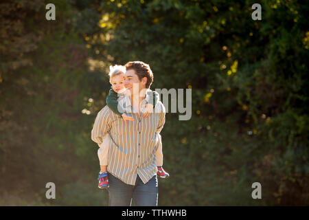 Padre Felice piggybacking figlio Foto Stock