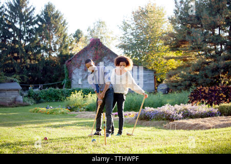 Giovane giocando croquet sul campo erboso Foto Stock
