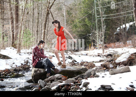 Giovane giocando con la neve dal fiume Foto Stock