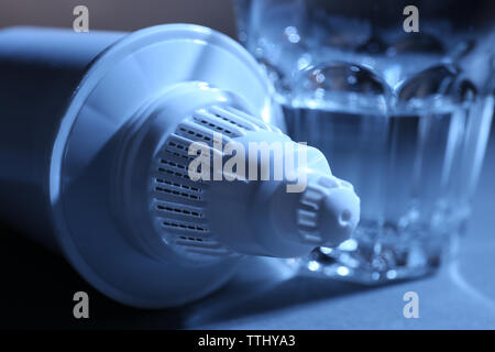 La cartuccia di filtro e un bicchiere di acqua, close-up Foto Stock