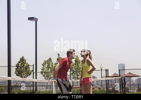 Coppia permanente al campo da tennis Foto Stock