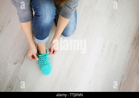 Donna di vincolare il laccio da scarpe sportive Foto Stock