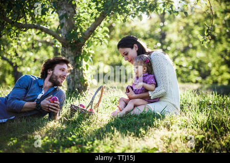 La famiglia felice con mela paniere di Orchard Foto Stock