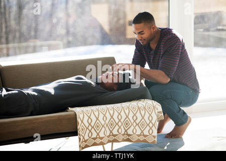 L'uomo accovacciato durante la riproduzione con la donna a casa Foto Stock