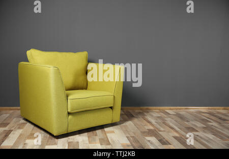 Poltrona verde sul grigio scuro dello sfondo a parete Foto Stock