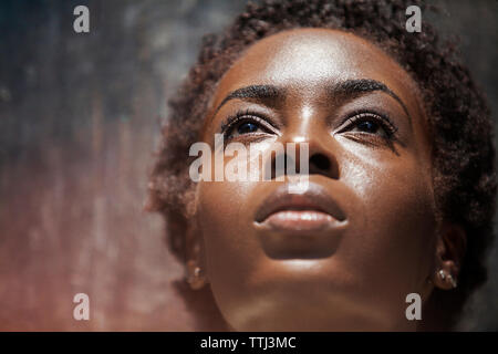 Close-up di pensosa donna appoggiata sulla parete Foto Stock