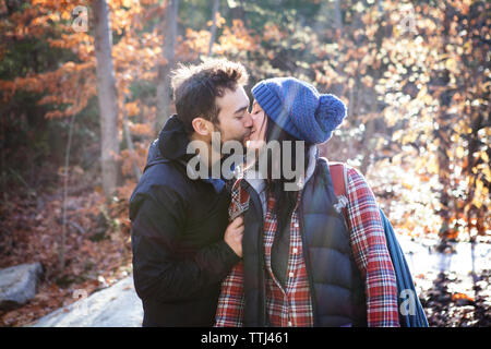 Coppia affettuoso bacio mentre si sta in piedi sul campo Foto Stock