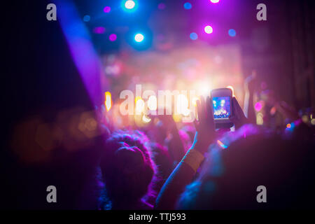 Uomo di fotografare con il cellulare in concerto Foto Stock