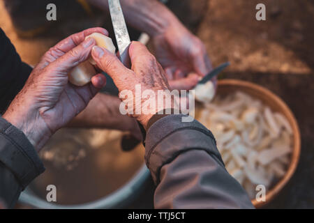 Le persone più anziane con le mani in mano la pelatura di patate Foto Stock