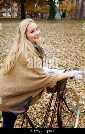 Ritratto di donna con la bicicletta sul campo Foto Stock