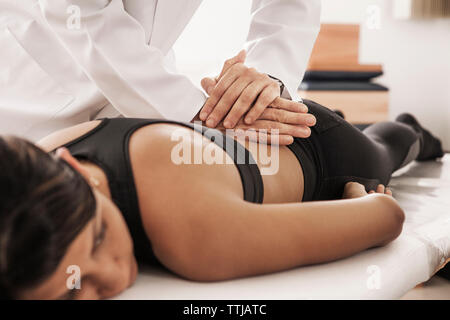 Immagine ritagliata di osteopata trattamento paziente femmina in clinica Foto Stock