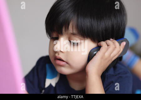 Ragazza con un telefono cellulare mentre si lavora su un computer portatile Foto Stock