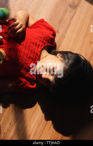 Ragazza indiana sdraiato sul pavimento in legno Foto Stock