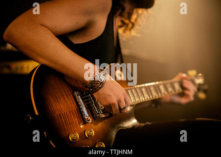 Sezione mediana dell'uomo la pratica di chitarra in rock music studio Foto Stock