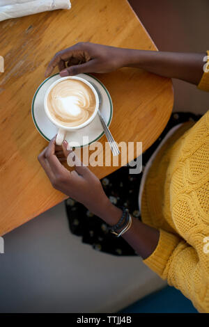 Vista aerea della donna con cappuccino in seduta cafe Foto Stock