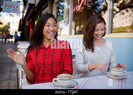Happy amici a sidewalk cafe Foto Stock
