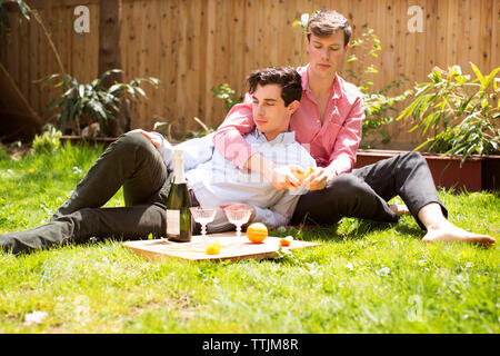 Coppia gay rilassante sul campo nel cortile posteriore Foto Stock