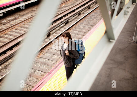 Elevato angolo di visione della donna in piedi sulla stazione ferroviaria Foto Stock