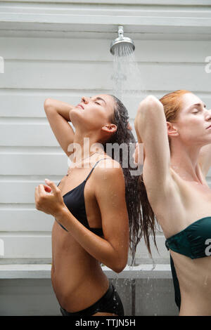 Le donne in bikini tenendo doccia Foto Stock