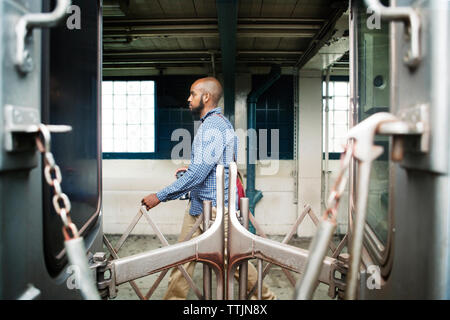 Vista laterale dell'uomo a piedi la stazione ferroviaria Foto Stock