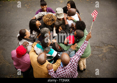 Famiglia abbracciando soldato mentre permanente sulla strada Foto Stock