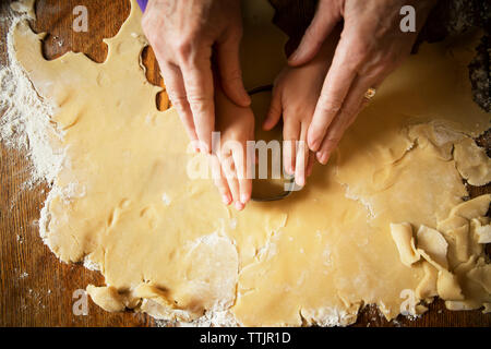 Immagine ritagliata di mani il taglio di pasta Foto Stock