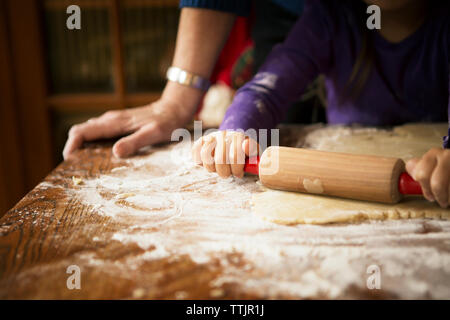 Immagine ritagliata della ragazza con la nonna preparare biscotti a casa Foto Stock