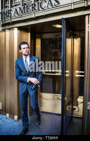 uomo d'affari che esce dalla porta girevole Foto Stock