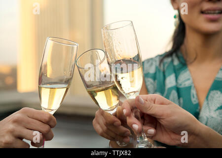 Immagine ritagliata delle mani di tostatura flauti champagne Foto Stock
