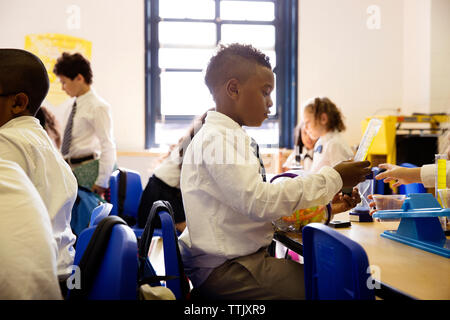 Agli studenti di mettere in pratica la scienza esperimento in laboratorio Foto Stock