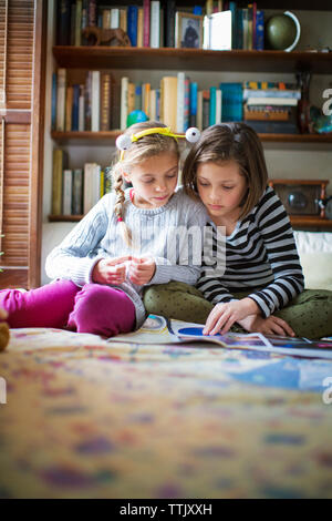 Ragazze che studiano seduti sul pavimento a casa Foto Stock