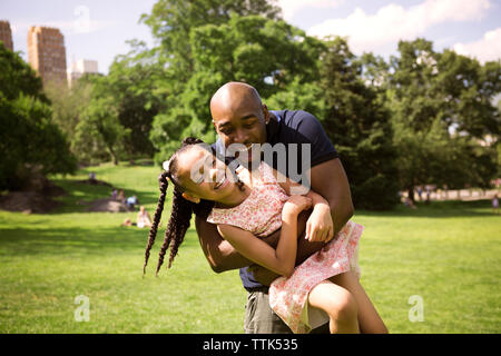 Felice padre e figlia godendo sul campo erboso a park Foto Stock