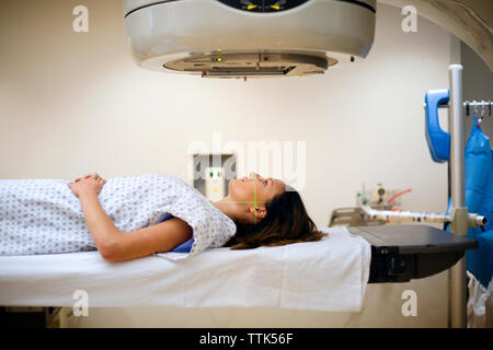 Paziente femmina giacente sotto la macchina a raggi X Foto Stock
