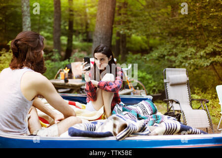 Donna Uomo fotografare mentre sedendo nel pick-up truck a forest Foto Stock