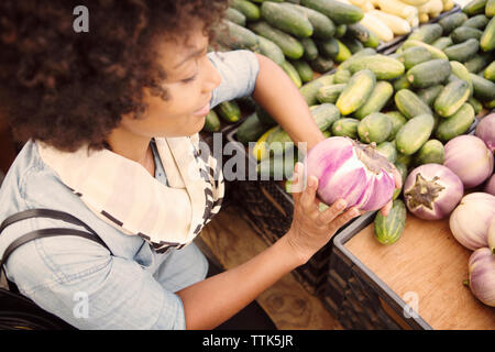 Elevato angolo di visione della donna vegetale di acquisto al mercato in stallo Foto Stock