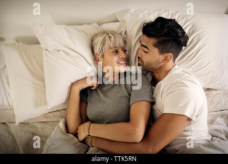 Vista aerea della coppia giovane rilassante sul letto di casa Foto Stock