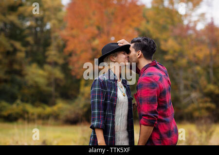 Affettuoso bacio uomo donna sul campo durante l'autunno Foto Stock