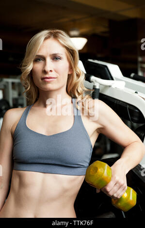 Ritratto di donna il sollevamento di pesi in palestra Foto Stock