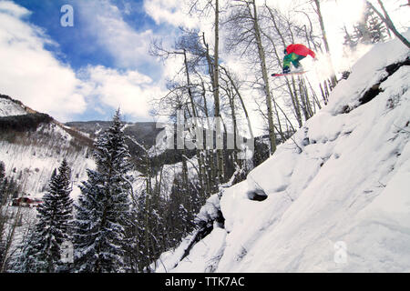Vista posteriore dell'uomo lo snowboard in montagna Foto Stock