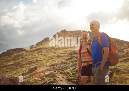 Allegro giovane permanente sulla montagna contro il cielo nuvoloso Foto Stock