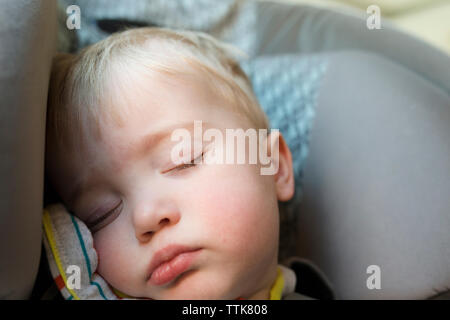 Close-up di carino stanco bambino dorme nel passeggino a casa Foto Stock