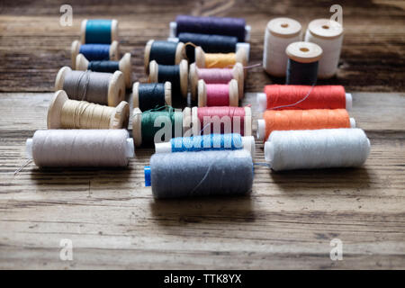 Varie bobine di filo sul tavolo di legno Foto Stock