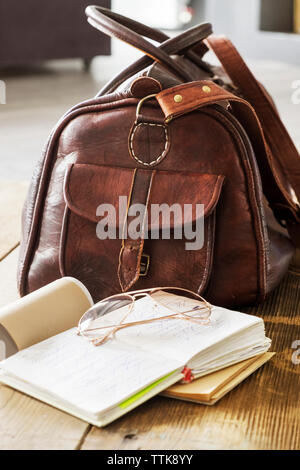 Borsa in pelle e i libri sul tavolo a home office Foto Stock